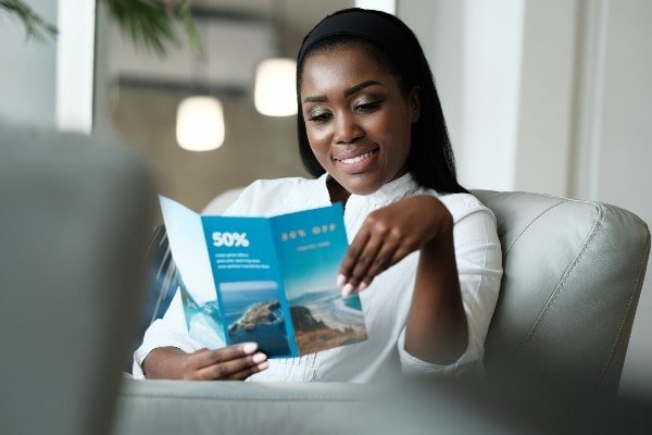 a woman reading a real estate brochure at home